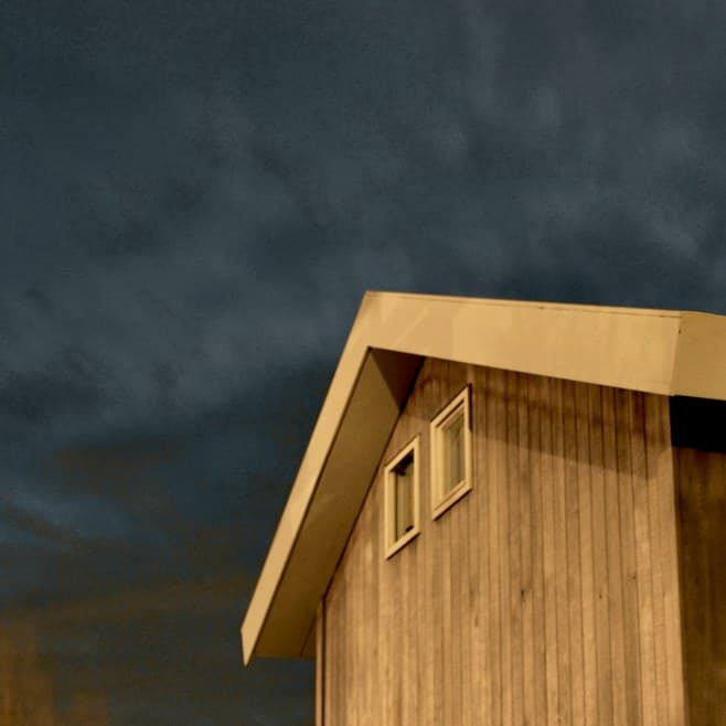 A home beneath a dark storm sky