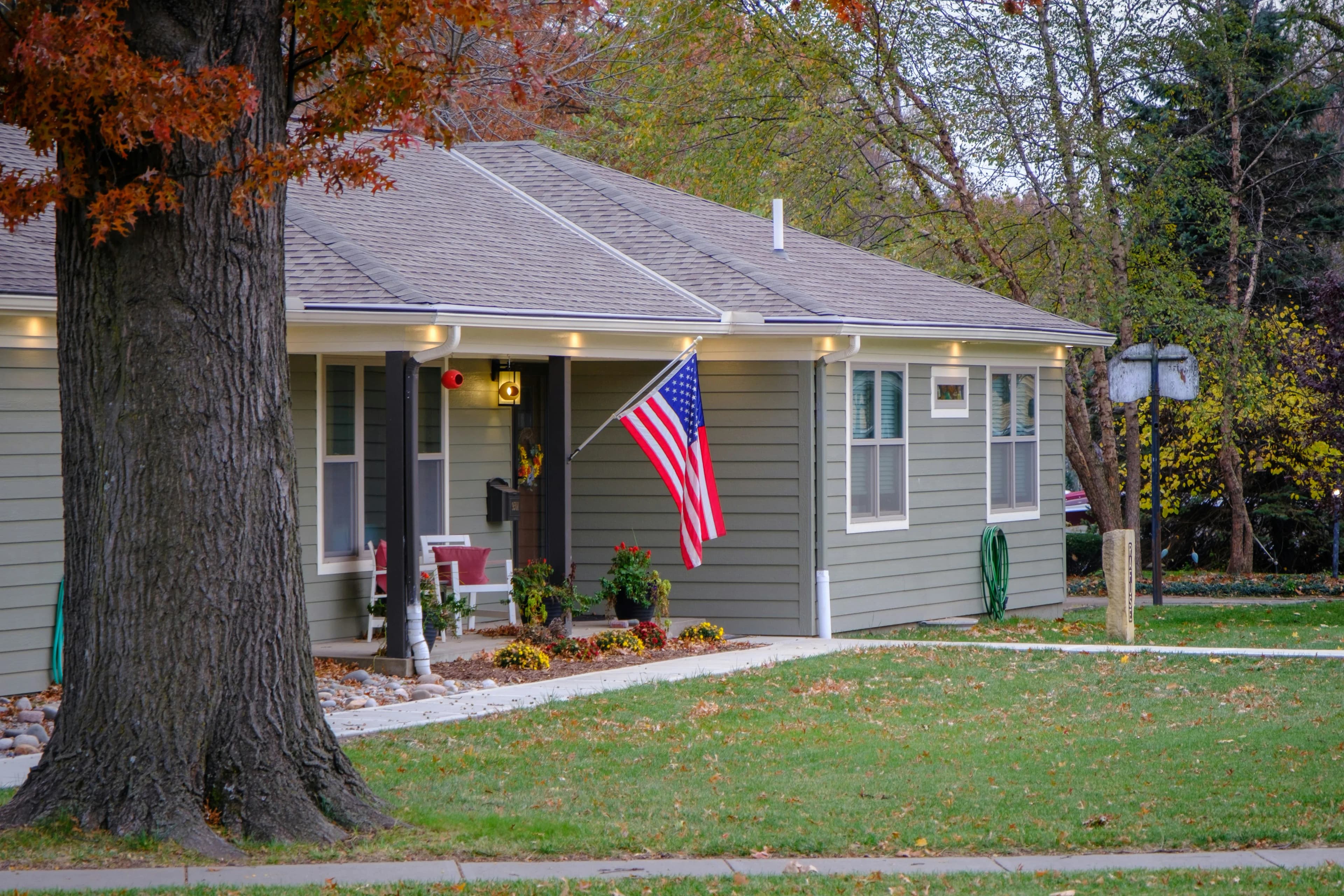 A one-story home in Kansas displays an American flag on their front porch.