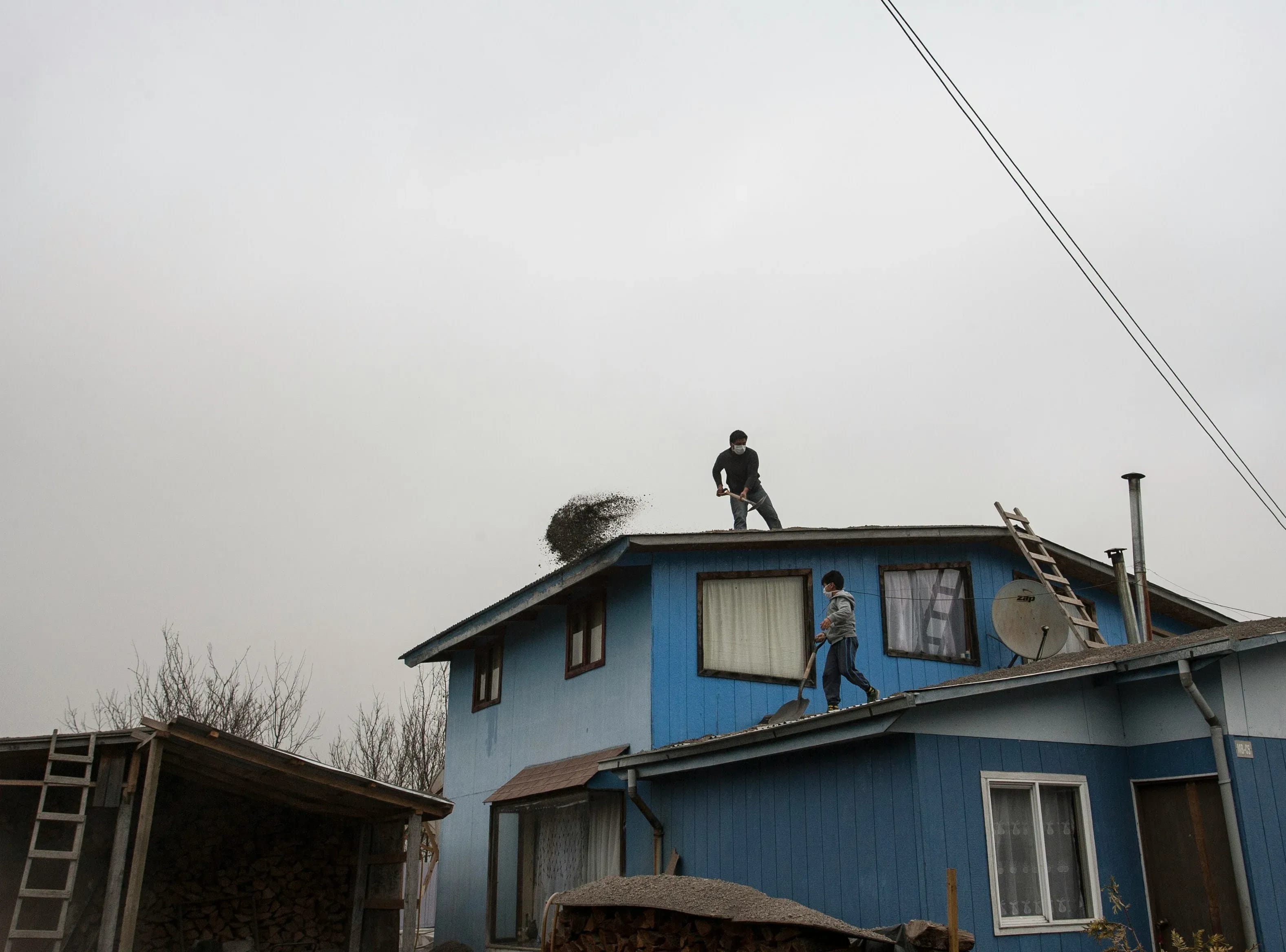 Roofers working to repair the roof of a two-story home following a hailstorm
