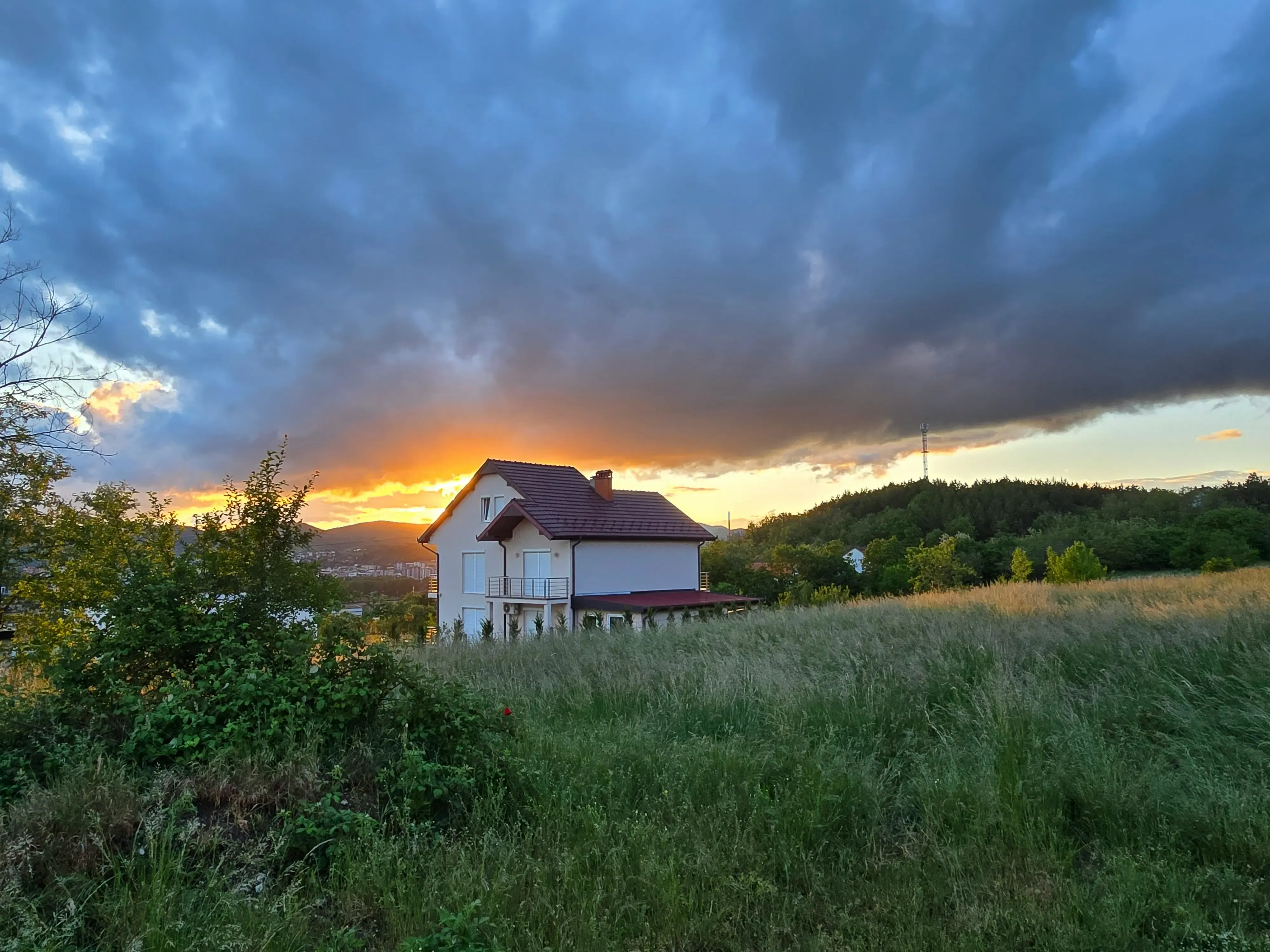 Thunderstorm clouds hang over a country home in the United States.