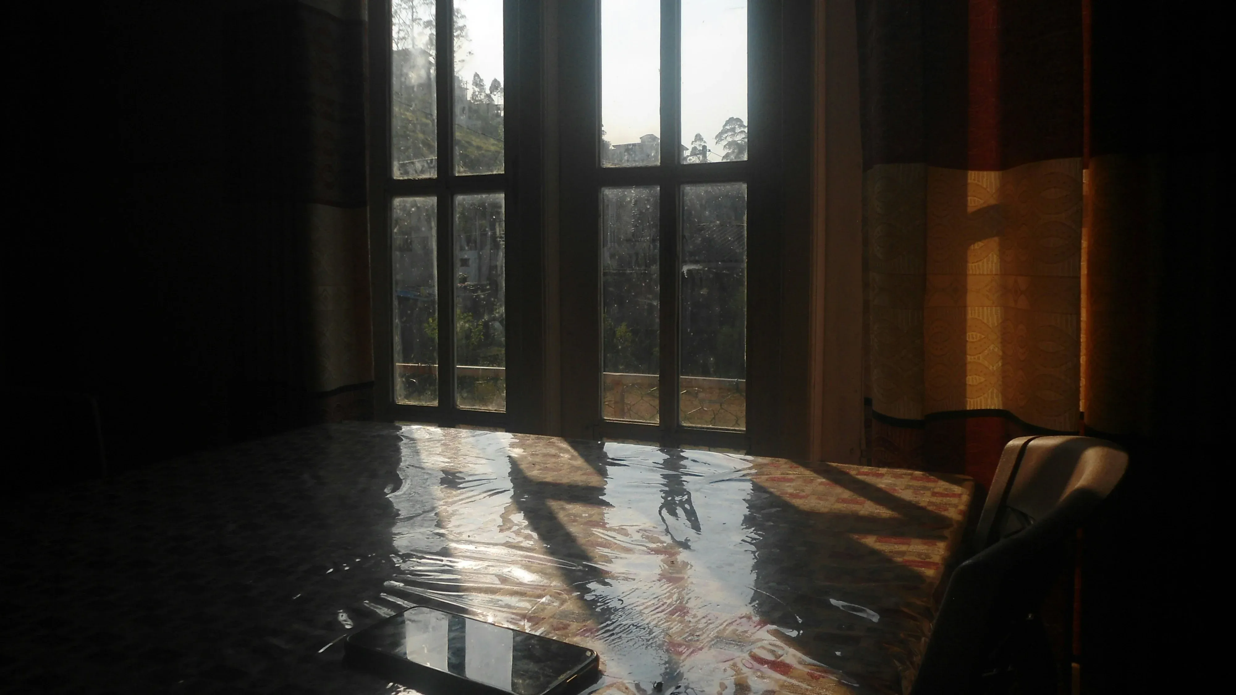 Standing floodwater fills a home as sunlight shines in through bare windows.
