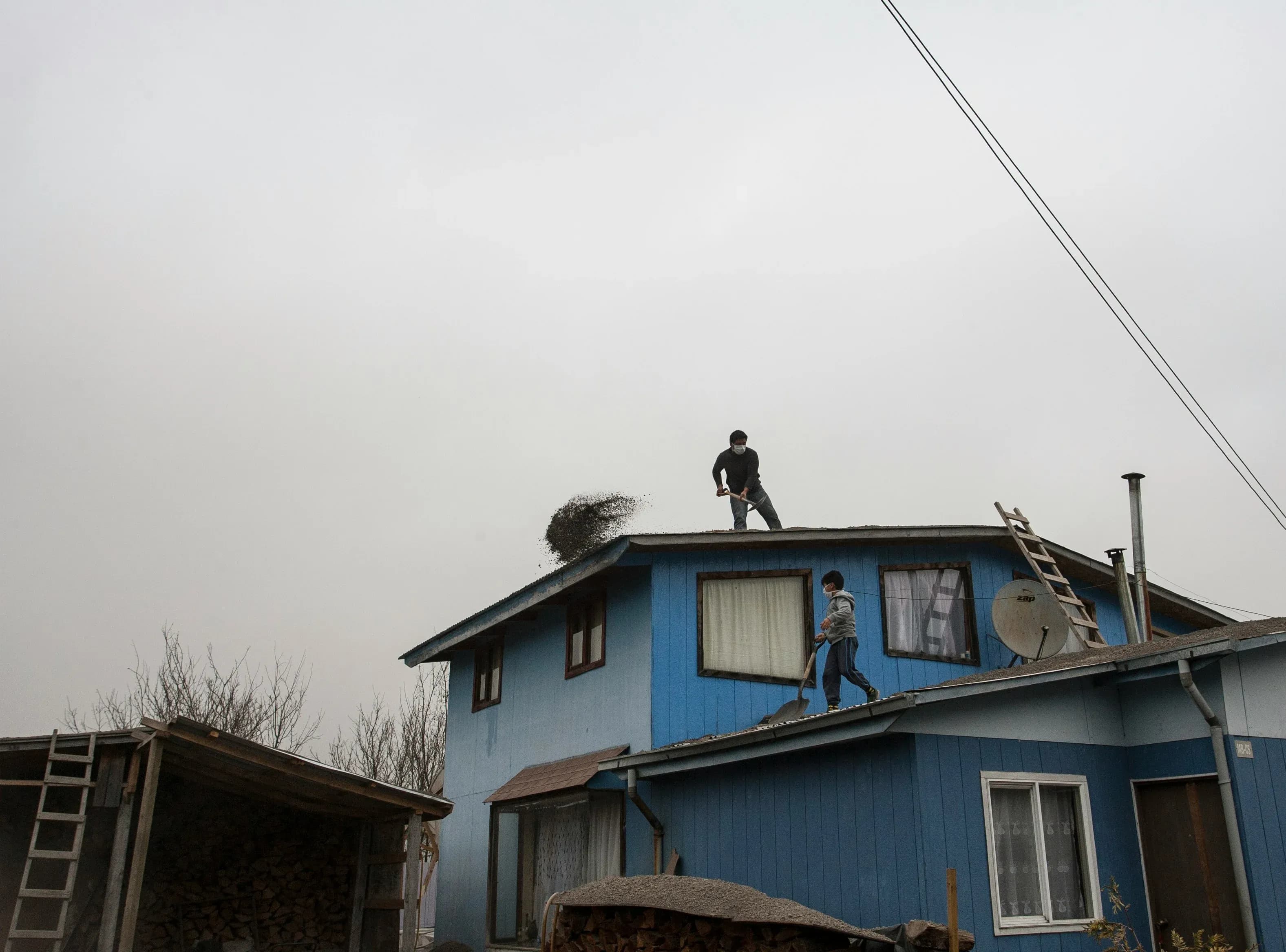 Roofers working to repair the roof of a two-story home following a hailstorm