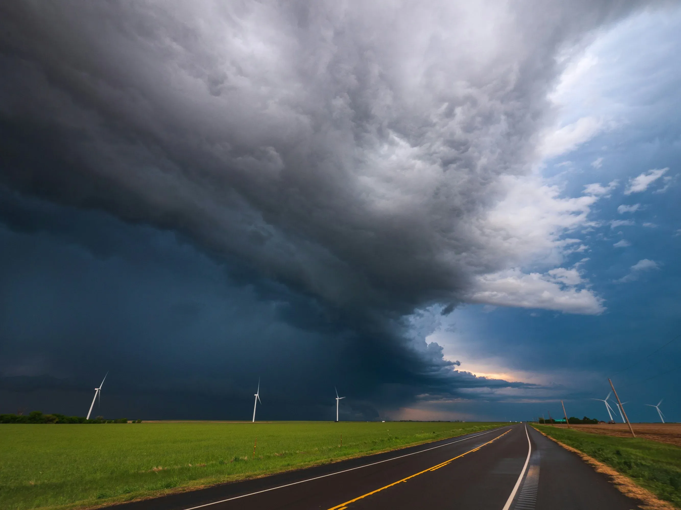 A large windstorm, indicated by dark clouds, moves over a Texas highway.